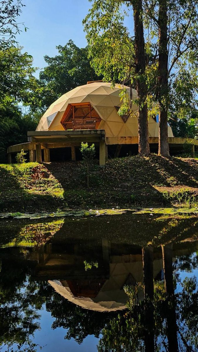 Domo do Romã Ashram refletido na água